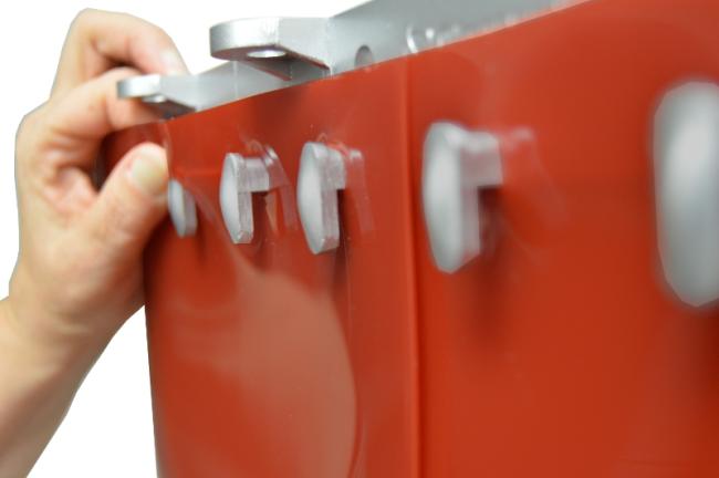 hand installing red PVC strip curtain onto a metal hook-on track with close-up of mounting pegs