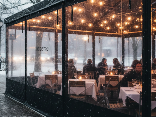 Restaurant outdoor dining area protected with clear vinyl windbreak panels in winter.