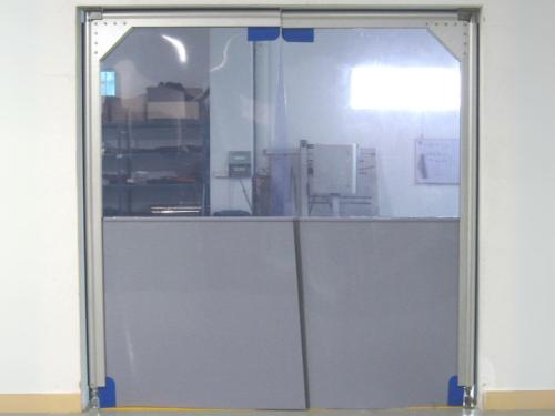 A swing door with a clear top section and a gray bottom section.